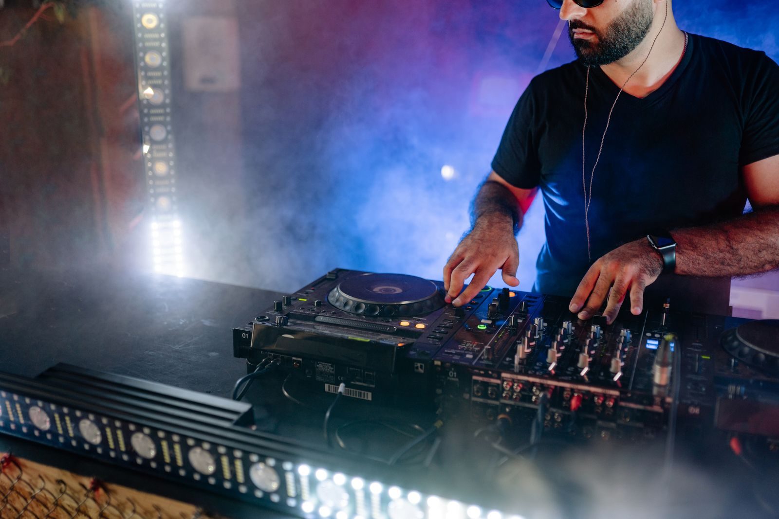 DJ performing at a mixer under event lighting